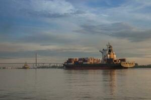 A shipping of maritime carrying container in boat on rever photo