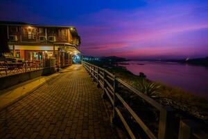 Wooden house beside river againts colorful sky photo