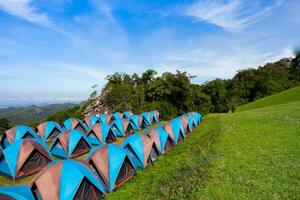 Camping tent on green grass againts sky photo