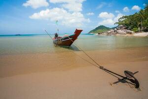 Long boat and white beach with mountain background photo