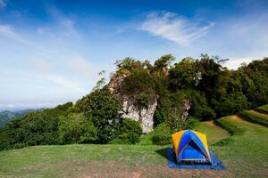 Camping tent on green grass againts sky photo