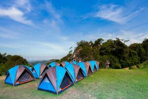 Camping tent on green grass againts sky photo