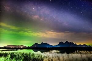 Milky way at nigh sky above mountain reflect on water photo