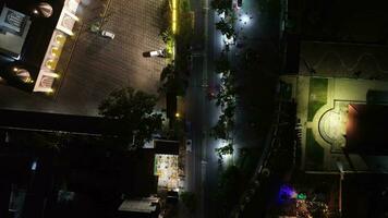 aéreo Visão do veículos dirigindo em iluminado rodovia estradas dentro a cidade às noite video