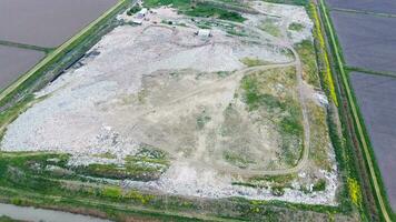 garbage dump with heaps of garbage and treatment facilities. Landfill of garbage outside the village photo