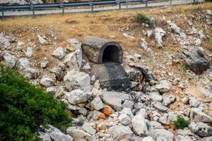 hormigón túnel para drenando aguas residuales debajo la carretera. foto