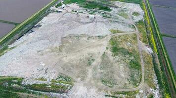 garbage dump with heaps of garbage and treatment facilities. Landfill of garbage outside the village photo