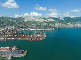 Industrial seaport, top view. Port cranes and cargo ships and barges. Loading and shipment of cargo at the port. View of the sea cargo port with a bird's eye view photo