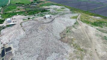 garbage dump with heaps of garbage and treatment facilities. Landfill of garbage outside the village photo