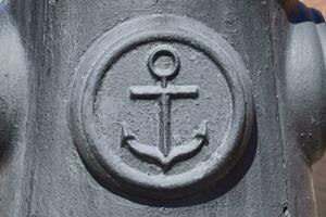 Icon of the sea anchor on the concrete. Symbol of seamen. photo