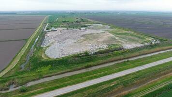 garbage dump with heaps of garbage and treatment facilities. Landfill of garbage outside the village photo