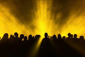 AI generated silhouette of crowd in front of stage lights at a music festival, Concert crowd shadows against vibrant yellow stage lights, AI Generated photo