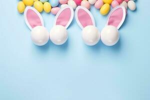 AI generated Colorful easter eggs on pastel blue background with copy space, Easter party concept, Top view photo of Easter bunny ears, white pink blue and yellow eggs on an isolated pastel