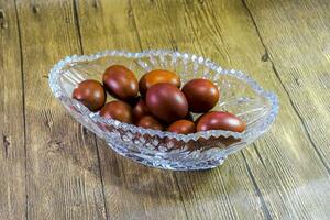 Painted Easter eggs in a crystal vase. Red painted chicken eggs for easter photo