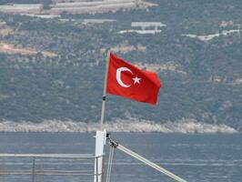 el bandera de Turquía revolotea en el viento en el cubierta de Placer yate. foto