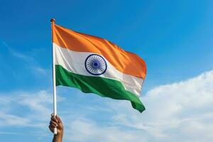 AI generated hand holding indian flag against blue sky with white clouds background, Close-up of a man's hand holding an India flag against the blue sky, AI Generated photo