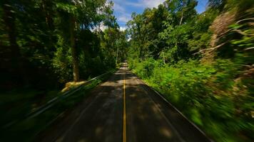 fpv velozes voar sobre a tropical estrada dentro a selva dentro Tailândia video