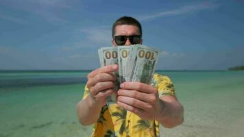 Man counting US dollars on tropical beach video