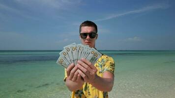 Man holds US dollars on tropical beach video