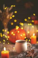 Autumn cozy composition. Tea in a mug, pumpkins and candles photo
