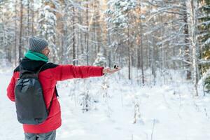 in the forest, the bird takes the seeds from his hand. feeding birds in winter. nuthatch, chickadee, titmouse photo