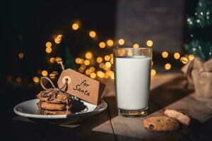 un apilar de galletas y vaso de Leche para Papa Noel en de madera antecedentes foto