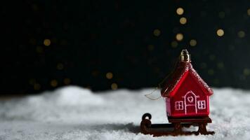 Christmas tree toy in the form of a red house on a sleigh in the snow. christmas, new year background photo