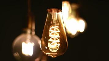 Spiral Retro light bulbs hanging on a dark background. Electricity, Vintage photo