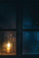 Christmas, new year, winter composition. Candle behind a frozen window photo