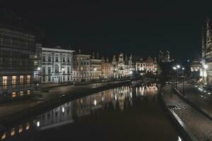 medieval edificios en graslei calle en el centrar de Gante por el río ley durante el noche. Bélgica más famoso histórico centro. Gante frente al mar durante medianoche foto