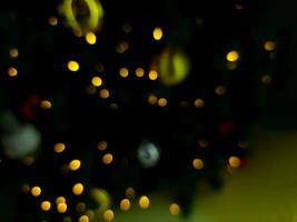abstract bokeh blur light christmas tree multi color orange and white glowing flare pattern black background photo