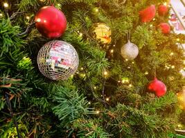 contento nuevo año acogedor hogar interior con Navidad árbol y guirnaldas pequeño rojo y plata pelotas. borroso luces dorado bokeh.feliz Navidad antecedentes. foto