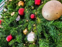 Happy new year cozy home interior with christmas tree and garlands small red and big gold balls. blurred lights golden bokeh.Merry Christmas background. photo