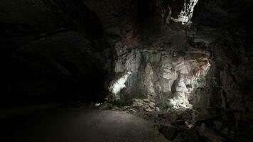 en grotta fylld med massor av stenar och en ljus på de slutet av den video