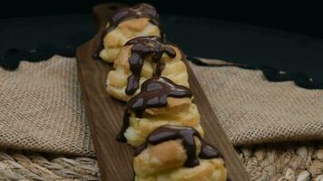 chocola profiterole draaien. hoog kwaliteit 4k beeldmateriaal video