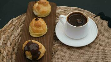 derritiendo chocolate profiteroles y café. alto calidad 4k imágenes video