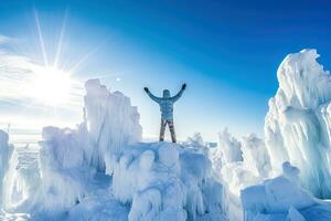 AI generated Rear view of a young climber joyfully raises his hands on top of an icy mountain photo