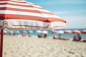 AI generated Close up image of a red and white horizontal striped beach umbrella on a background of a beach with sun loungers and blue sea photo