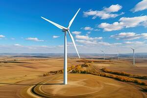 ai generado aéreo ver de un viento turbina torre en un campo con amarillo césped debajo un nublado azul cielo foto