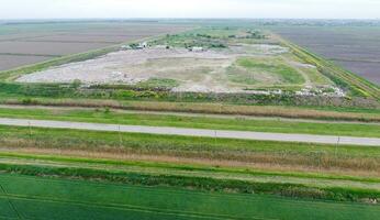 garbage dump with heaps of garbage and treatment facilities. Landfill of garbage outside the village photo