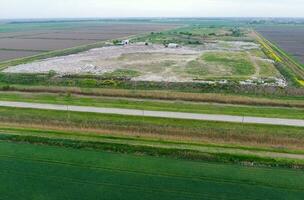 garbage dump with heaps of garbage and treatment facilities. Landfill of garbage outside the village photo