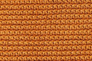 Orange knitted fabric texture background. Top view. Copy, empty space for text photo