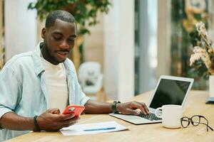 Man working male table african black phone lifestyle modern portrait adult laptop computer photo