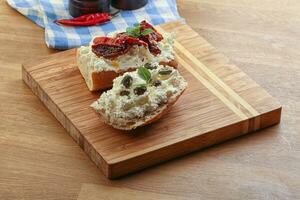 bruschetta with soft cheese capers and tomato photo