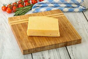 Piece of natural organic cheese over board photo