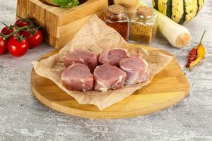 Uncooked raw pork tenderloin medallions photo