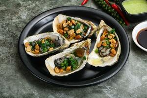 Open half oysters with green onion photo