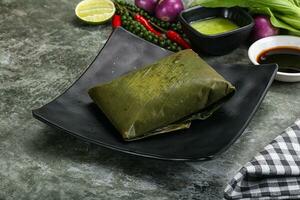 Asian cuisine - rice with filling in banana leaf photo