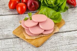 Slices boiled sausages for breakfast photo