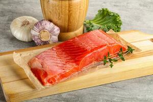 Raw salmon fillet over board photo